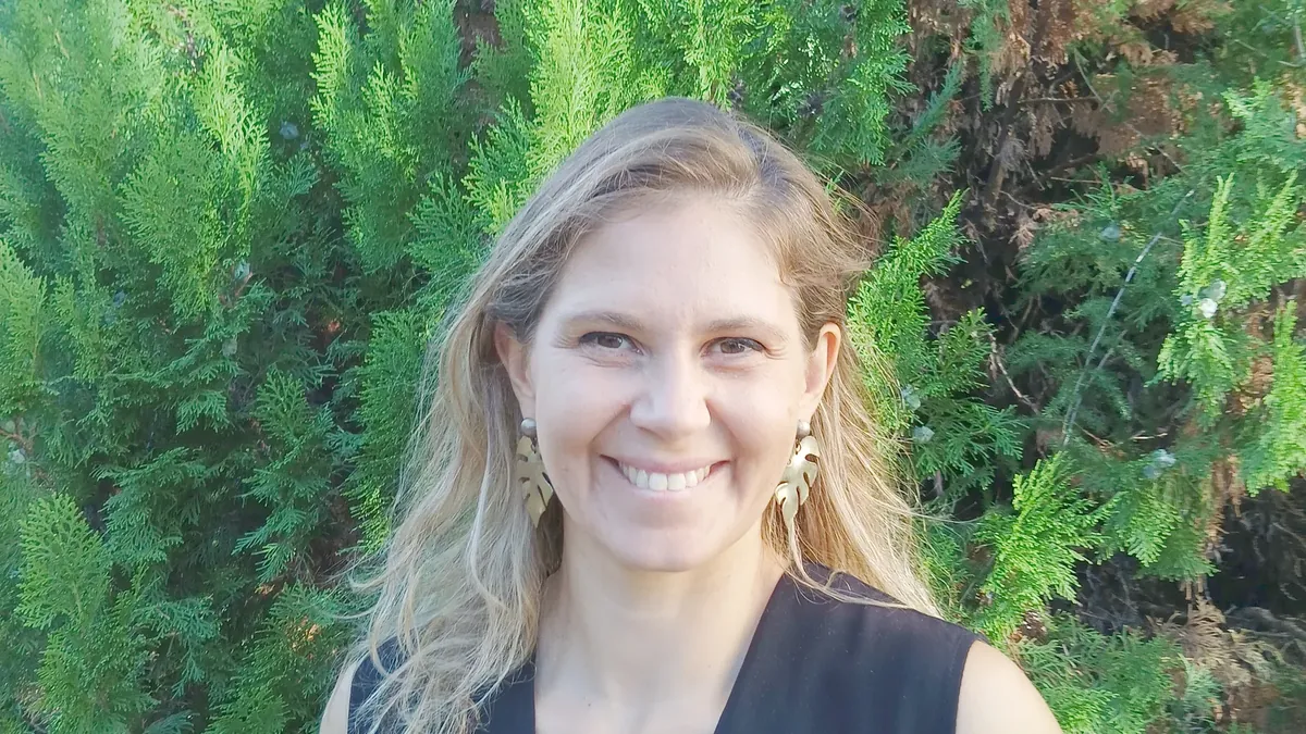 Charlotte Pons, sophrologue, souriante dans son jardin