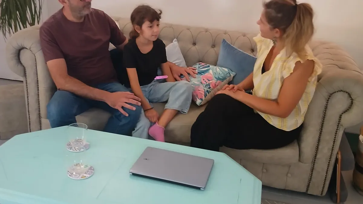 Charlotte Pons, sophrologue, en temps d’échange assis avec un parent et un enfant au cabinet