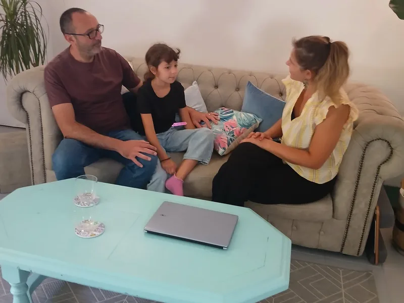 Charlotte Pons en consultation avec un parent et son enfant, dans son cabinet