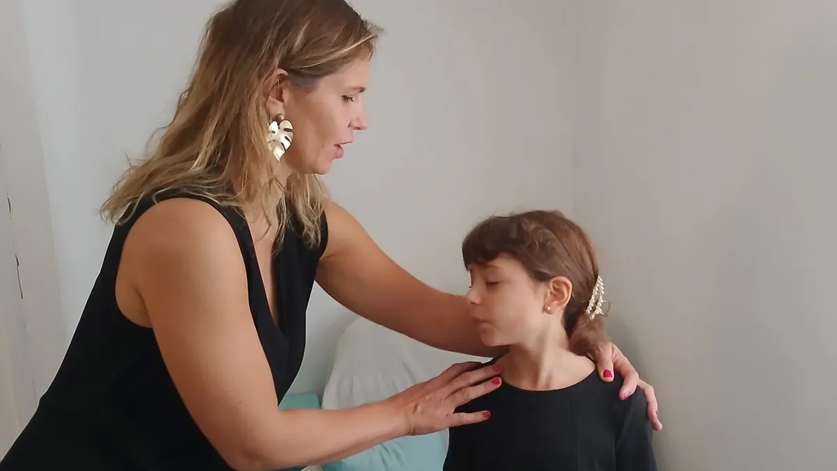 Charlotte Pons pose les mains sur les épaules d’un enfant pendant un exercice de sophrologie